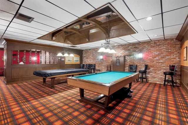 a room with pool table and windows