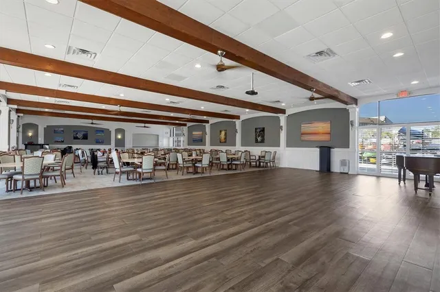 a living room with lots of furniture wooden floor and kitchen view