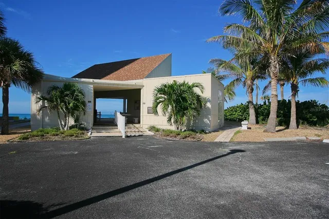 a view of a house with a yard and palm trees