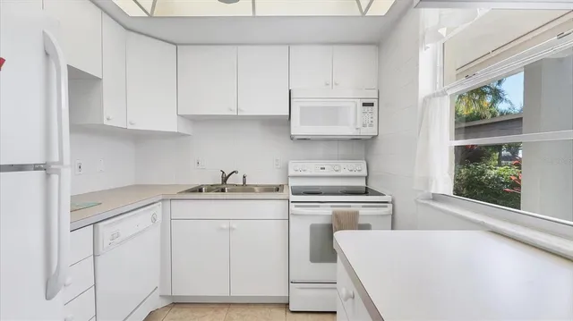 a kitchen with cabinets appliances and a window