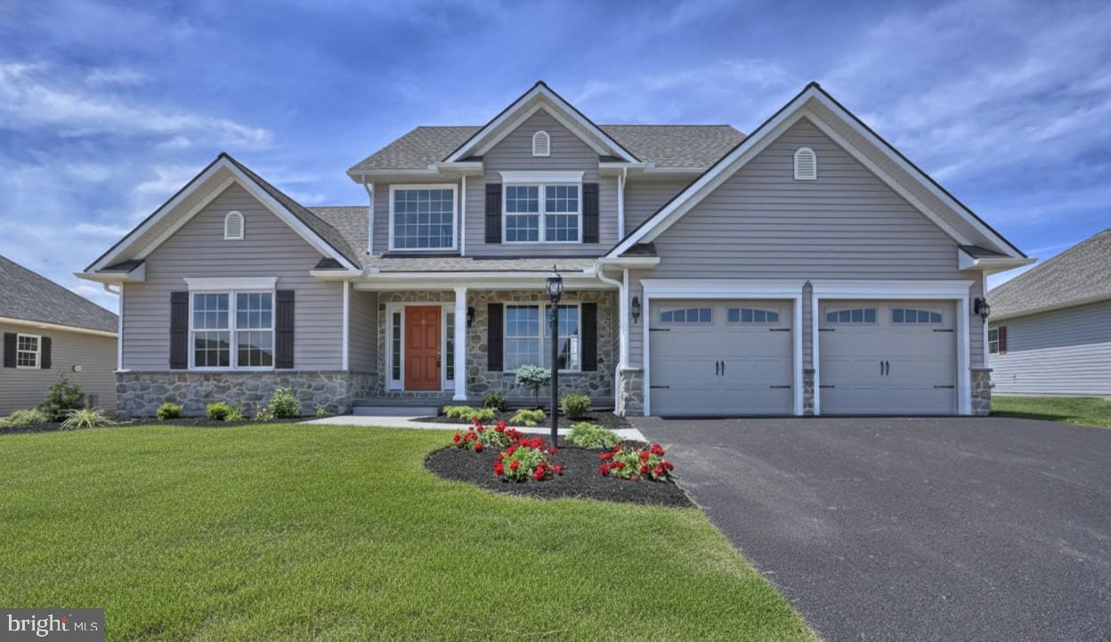 a front view of a house with a garden and yard