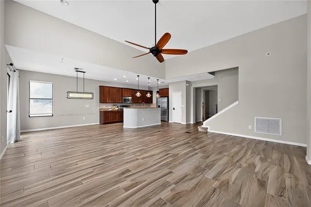 a view of a kitchen with wooden floor and a ceiling fan