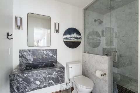 a bathroom with a toilet sink and mirror