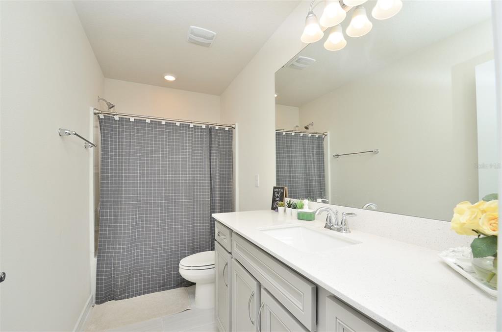 4963 Royal Point Avenue Kissimmee, FL 34746 - Photo 13 of 27 a bathroom with a sink a toilet and mirror