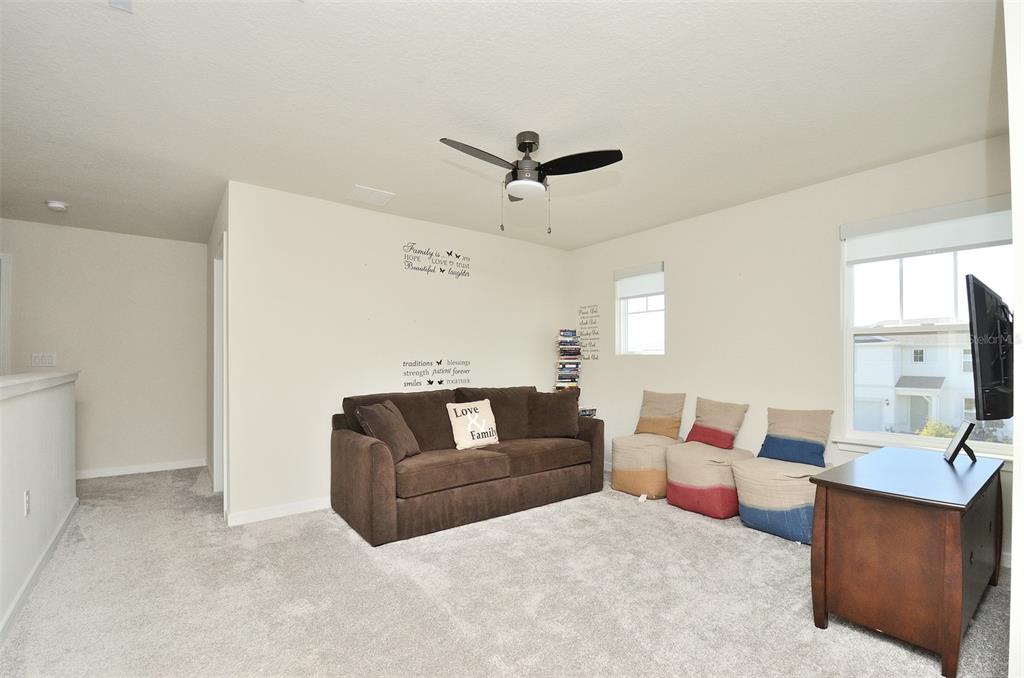 4963 Royal Point Avenue Kissimmee, FL 34746 - Photo 23 of 27 a living room with furniture and a flat screen tv