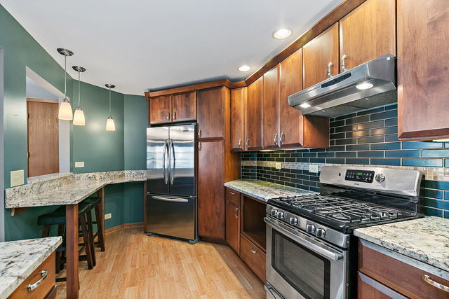 1871 Fox Run Drive, Unit A Elk Grove Village, IL 60007 - Photo 12 of 27 a kitchen with stainless steel appliances granite countertop a stove and a sink