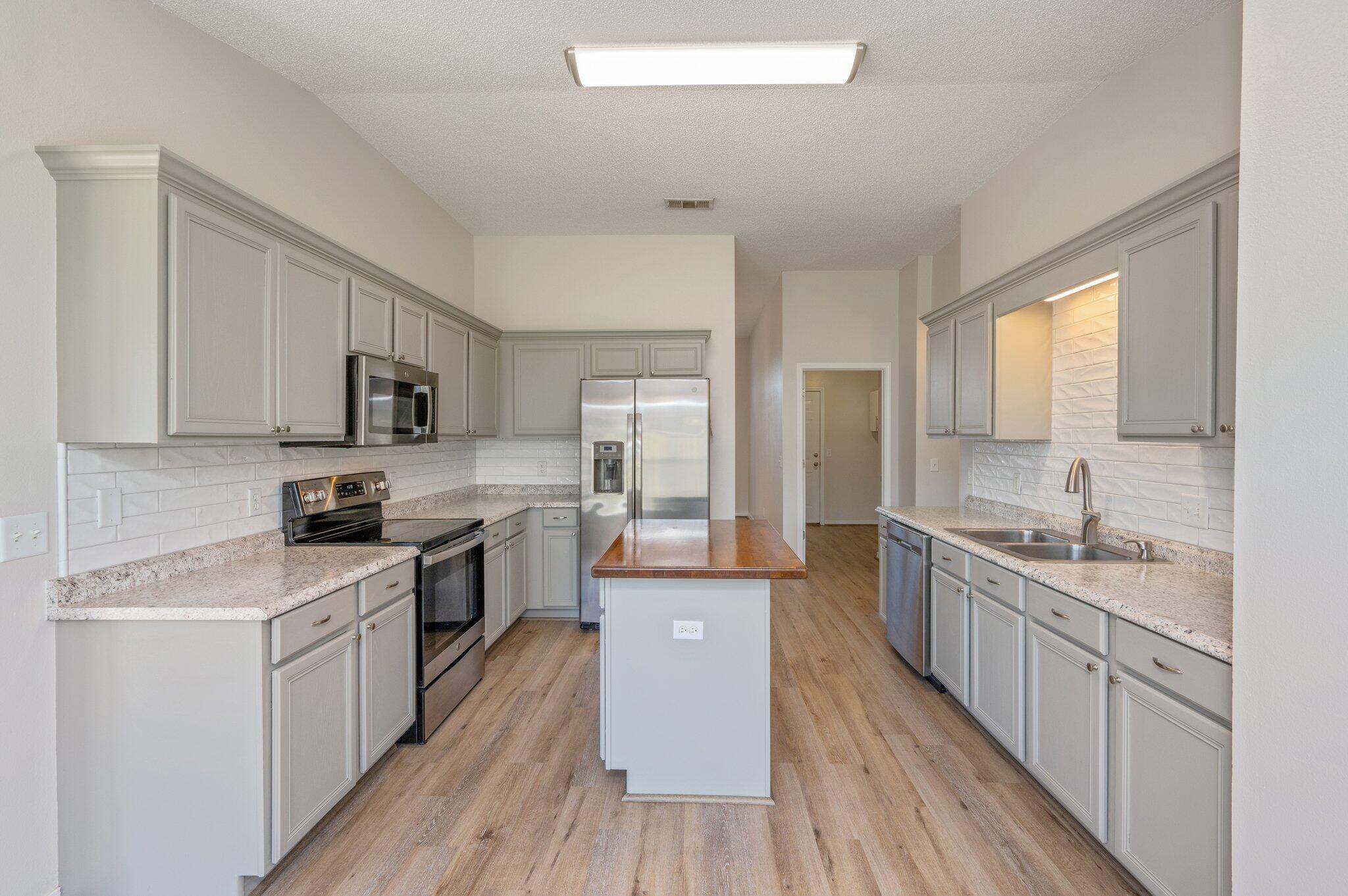 459 Jillian Drive Crestview, FL 32536 - Photo 11 of 46 a kitchen with stainless steel appliances granite countertop wooden cabinets a sink dishwasher a stove and a refrigerator with wooden floor
