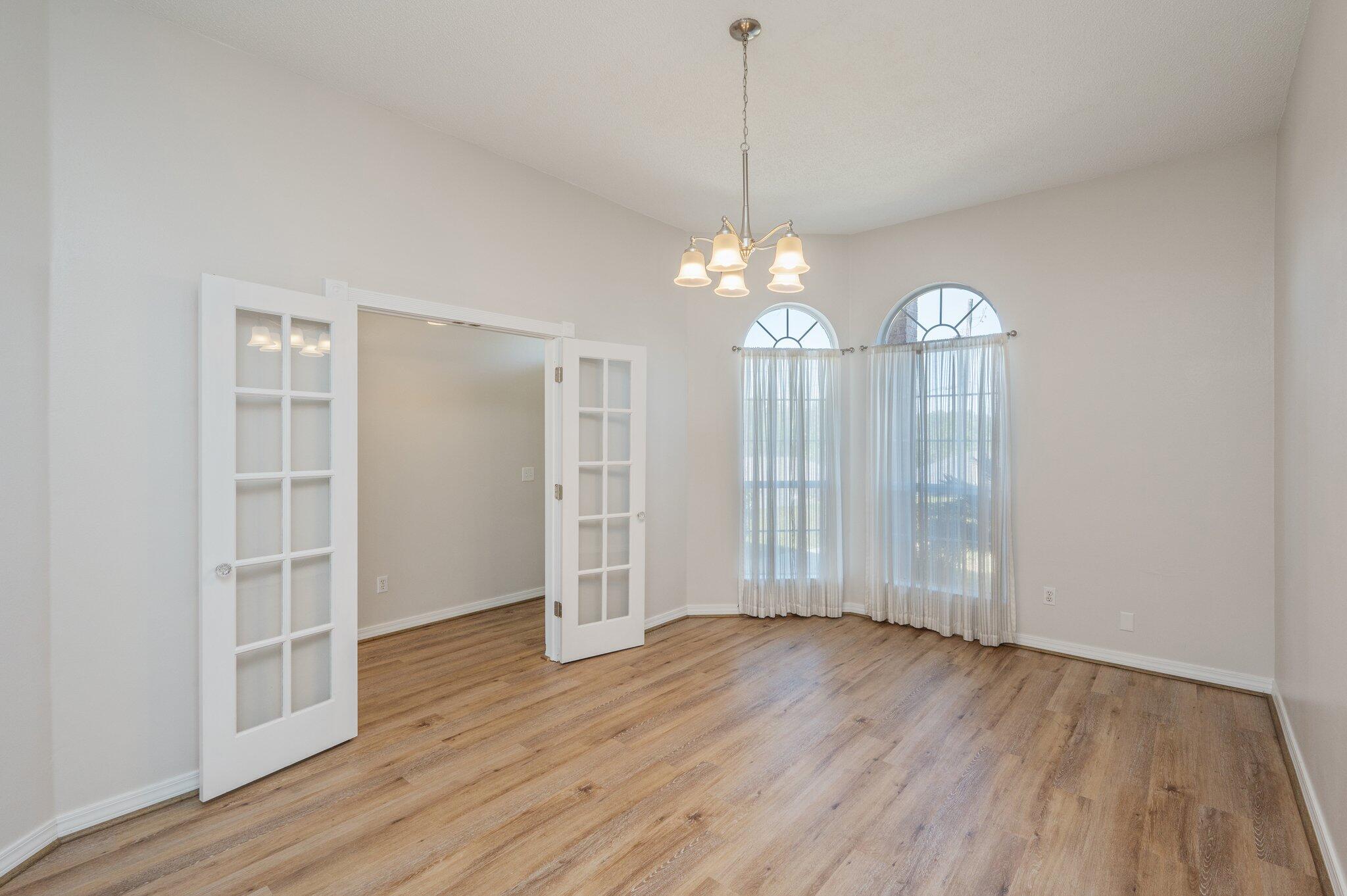 459 Jillian Drive Crestview, FL 32536 - Photo 18 of 46 an empty room with wooden floor chandelier and windows
