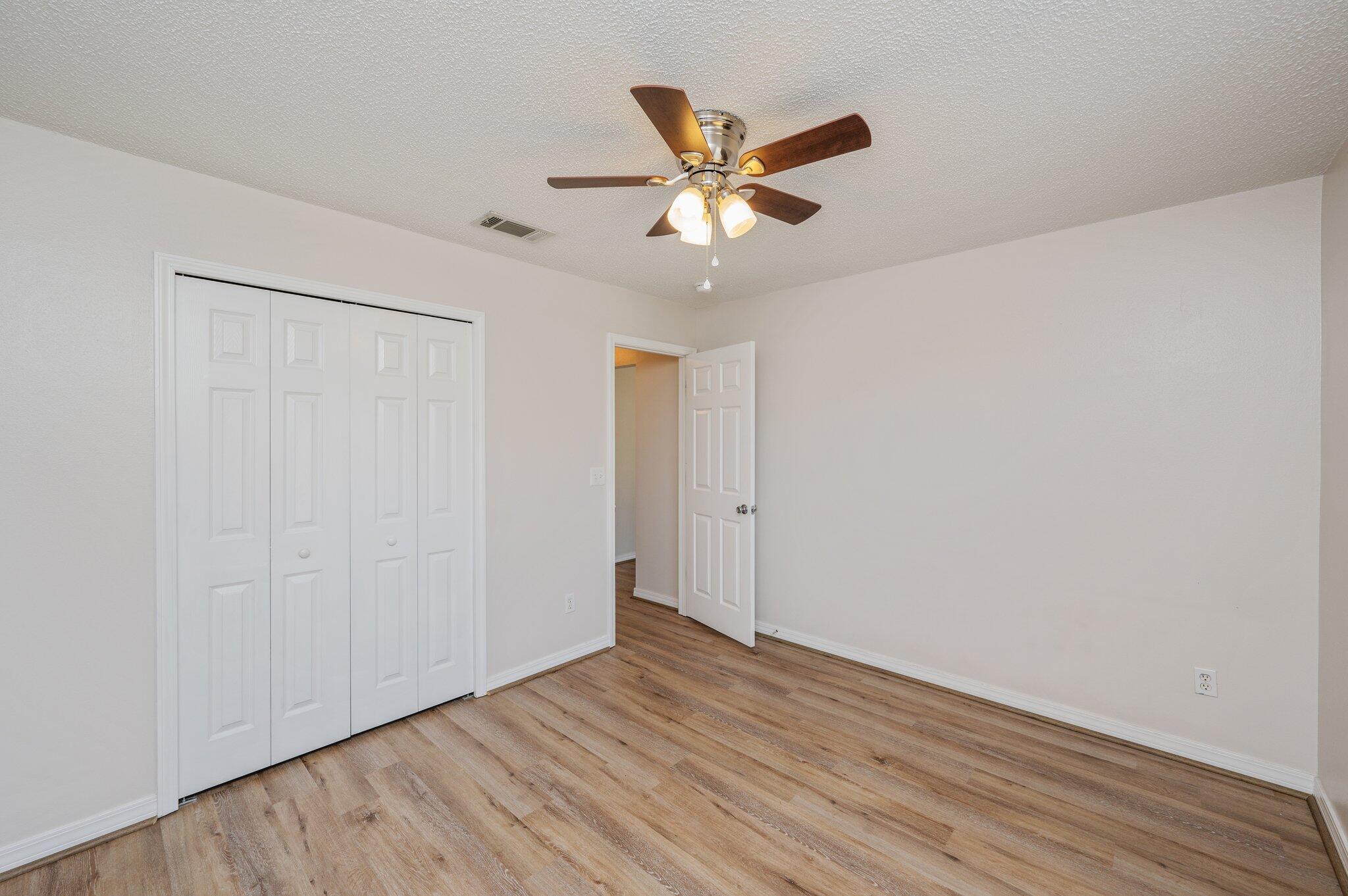459 Jillian Drive Crestview, FL 32536 - Photo 32 of 46 a view of an empty room with wooden floor and a ceiling fan