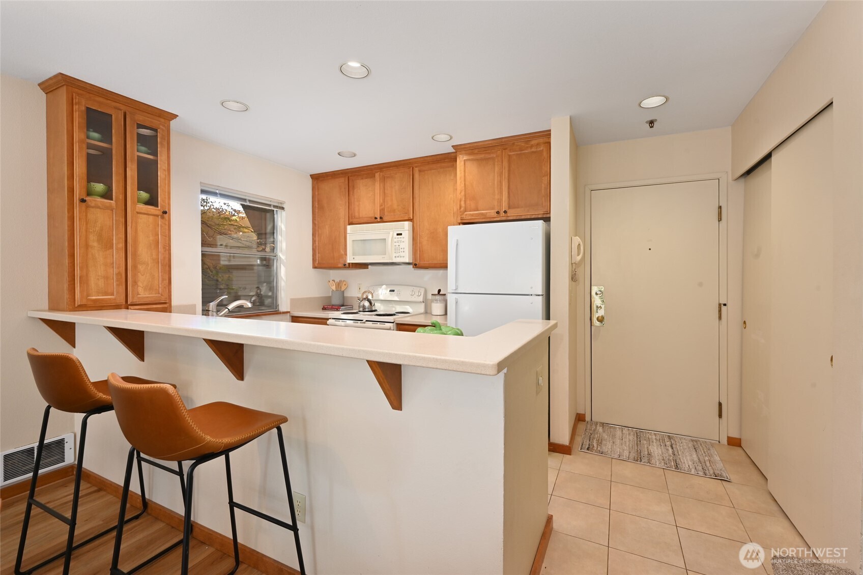 2827 Franklin Avenue East, Unit N9 Seattle, WA 98102 - Photo 7 of 23 a kitchen with a refrigerator a stove a sink and a dining table with wooden cabinet