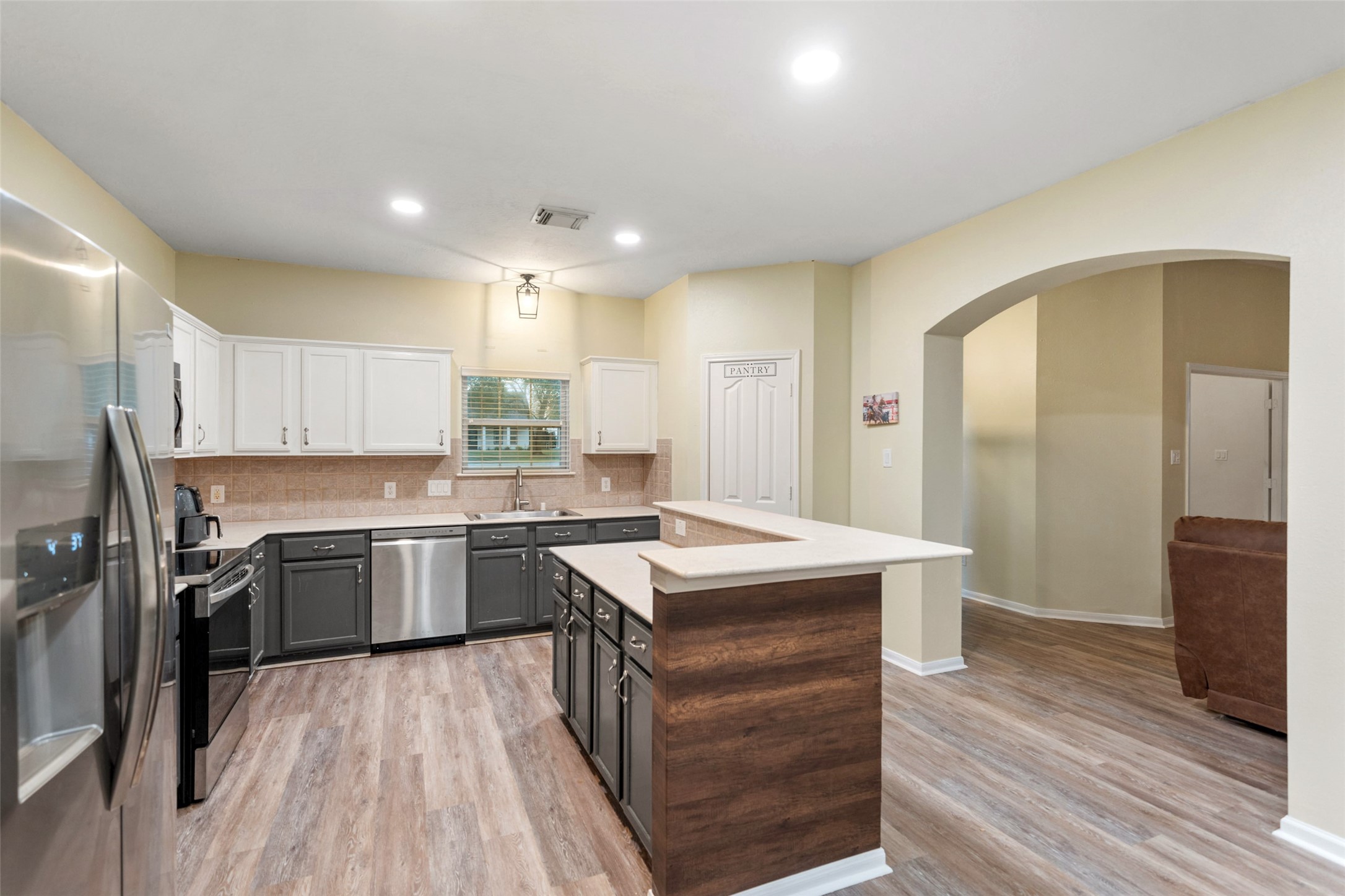 118 Pin Oak Lane Hempstead, TX 77445 - Photo 11 of 33 Open-concept kitchen with breakfast bar seating, pantry storage, and seamless flow to living areas.