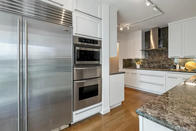 a kitchen with a refrigerator and a stove top oven