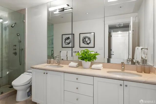 a bathroom with a granite countertop sink mirror and toilet