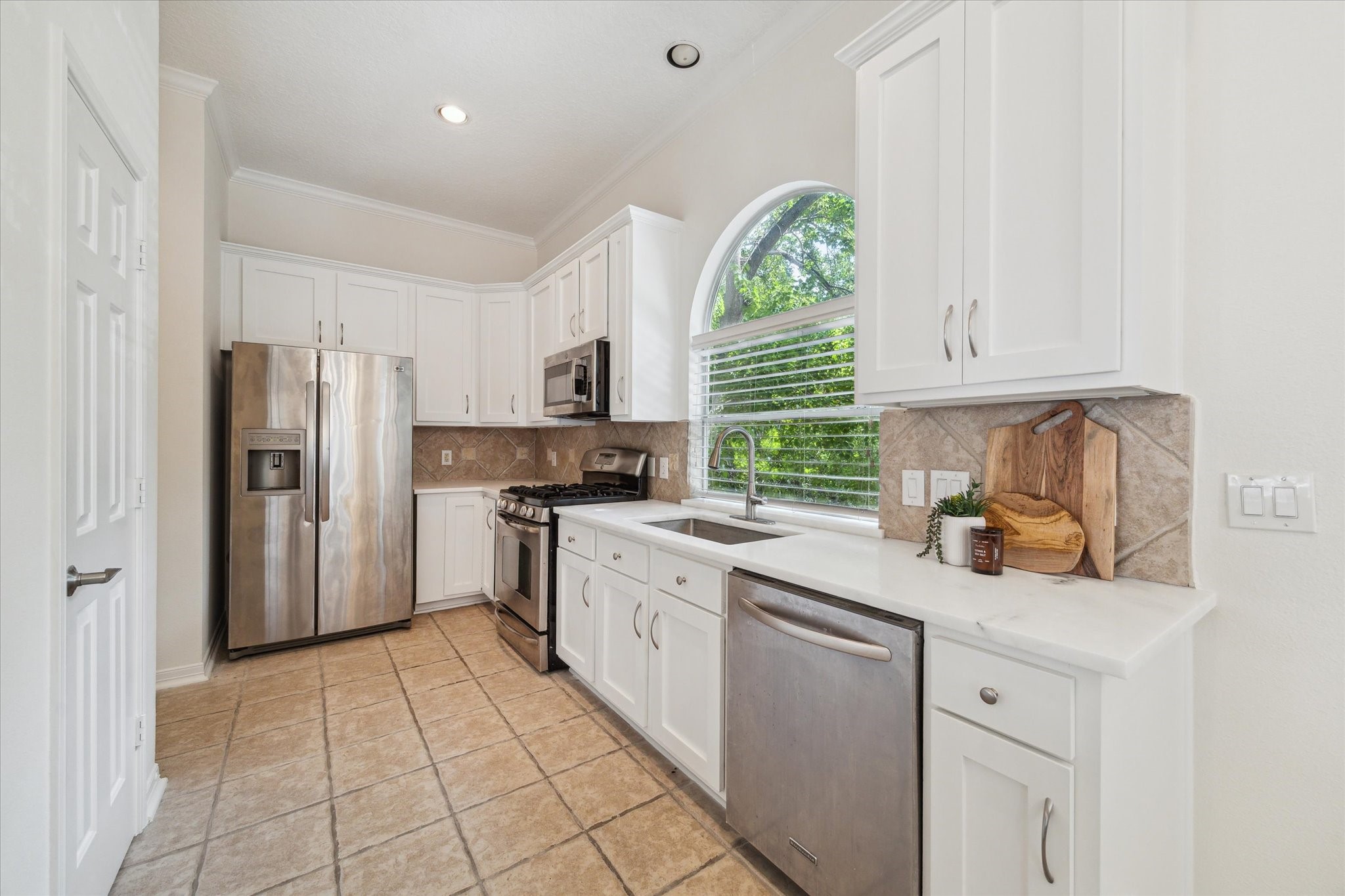 909 Reinicke Street Houston, TX 77007 - Photo 7 of 19 Kitchen featuring stainless steel appliances, ample storage, and new quartz countertops.
