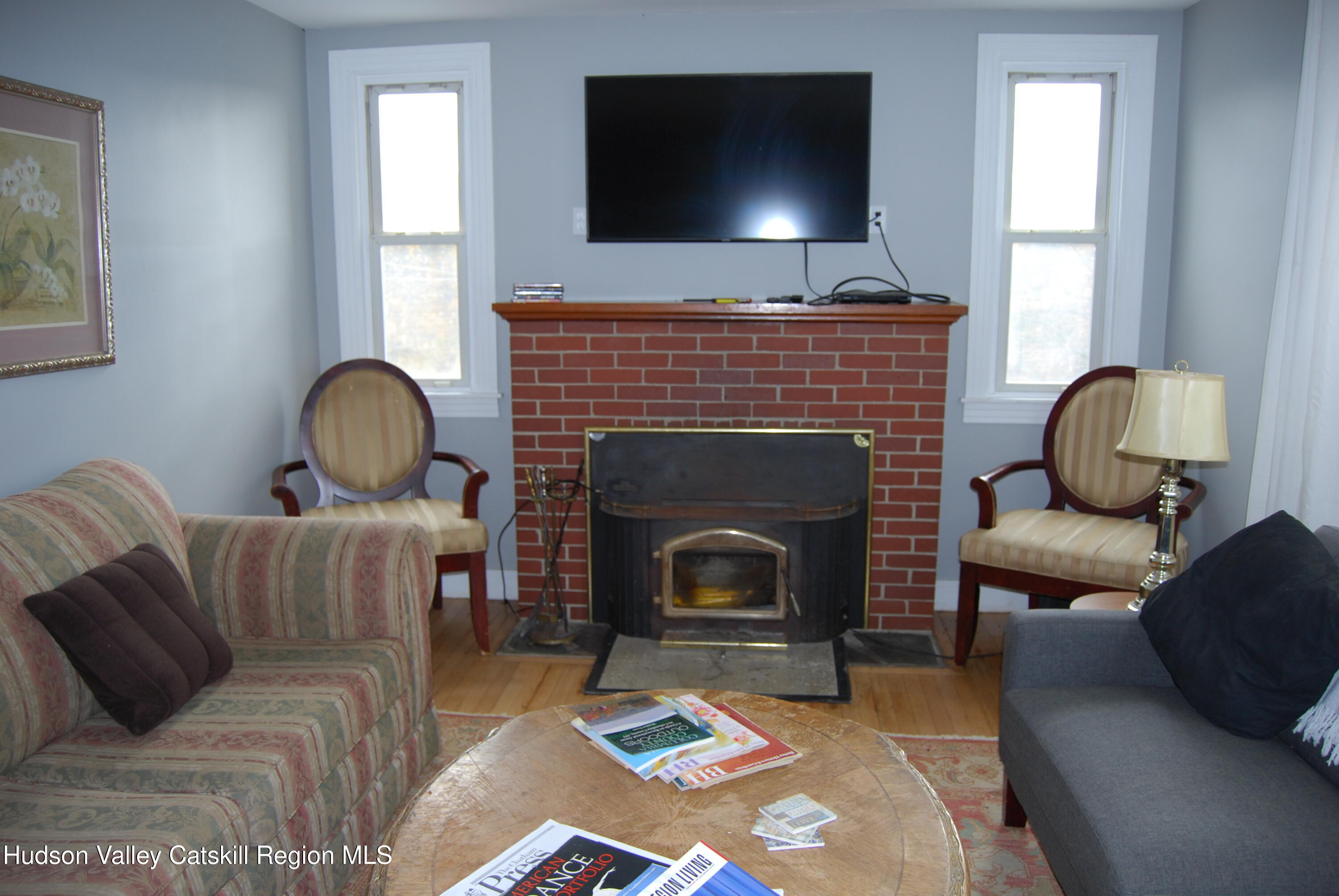 7 Harmon Heights Road Chatham, NY 12037 - Photo 5 of 25 a living room with furniture a flat screen tv and a fireplace
