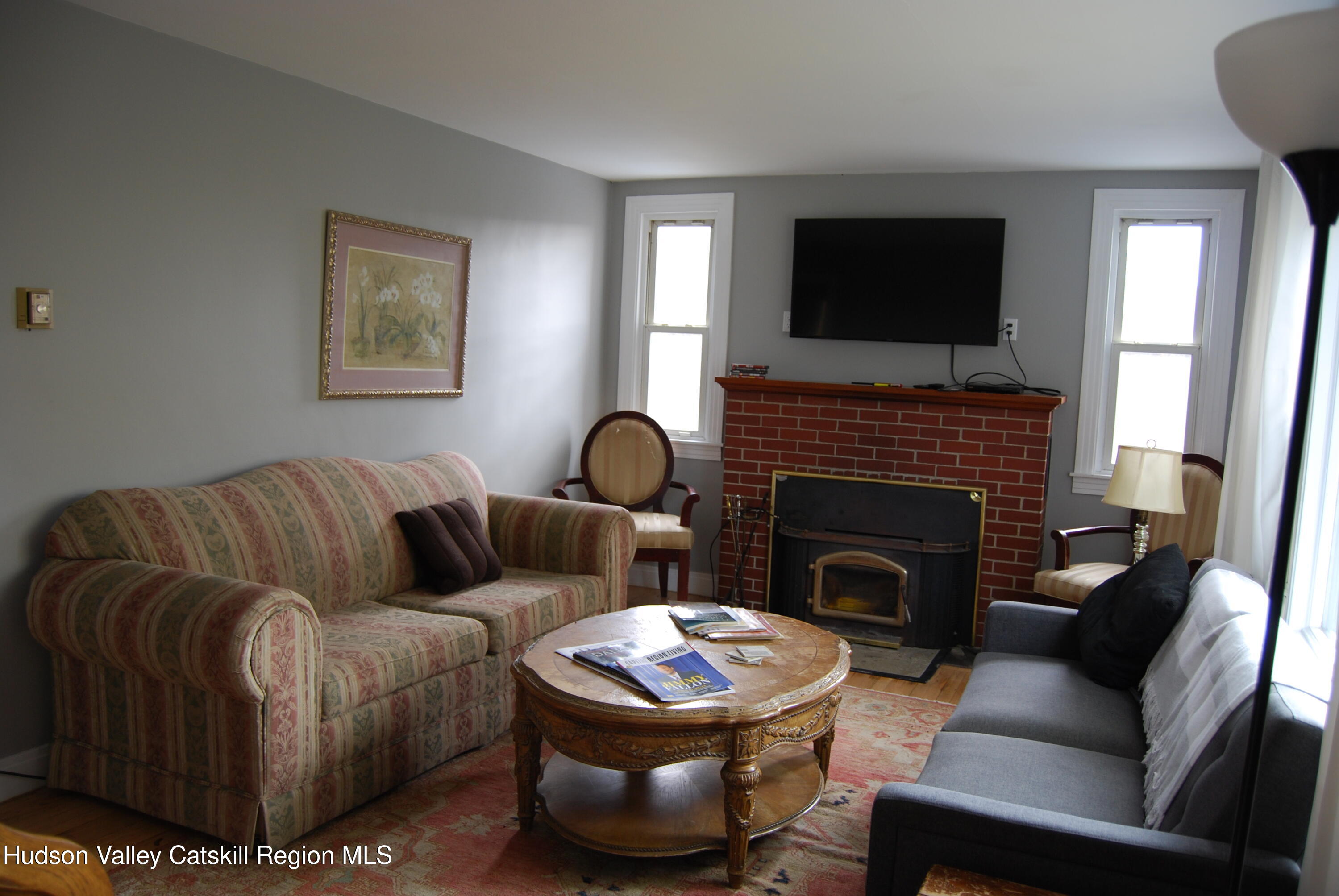 7 Harmon Heights Road Chatham, NY 12037 - Photo 7 of 25 a living room with furniture a flat screen tv and a fireplace