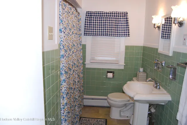 a bathroom with a sink toilet and mirror