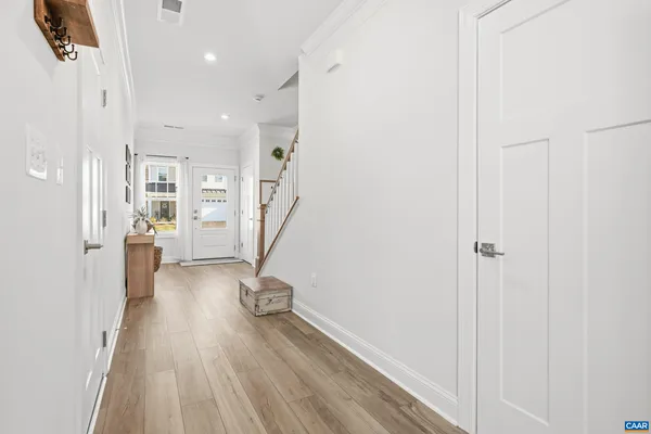 a view of a hallway with wooden floor and staircase