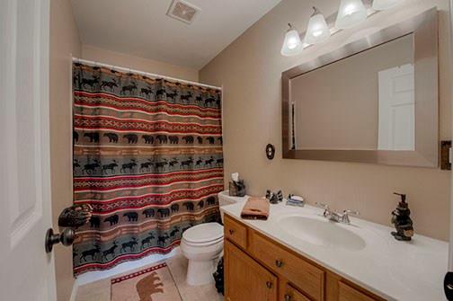 455 Apache Trail Jefferson, CO 80456 - Photo 21 of 34 a bathroom with a sink a toilet a mirror and shower curtain