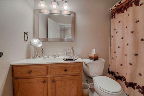 455 Apache Trail Jefferson, CO 80456 - Photo 27 of 34 a bathroom with a granite countertop toilet sink and mirror