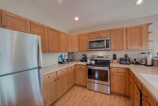 455 Apache Trail Jefferson, CO 80456 - Photo 10 of 34 a kitchen with a refrigerator a stove top oven a sink and cabinets