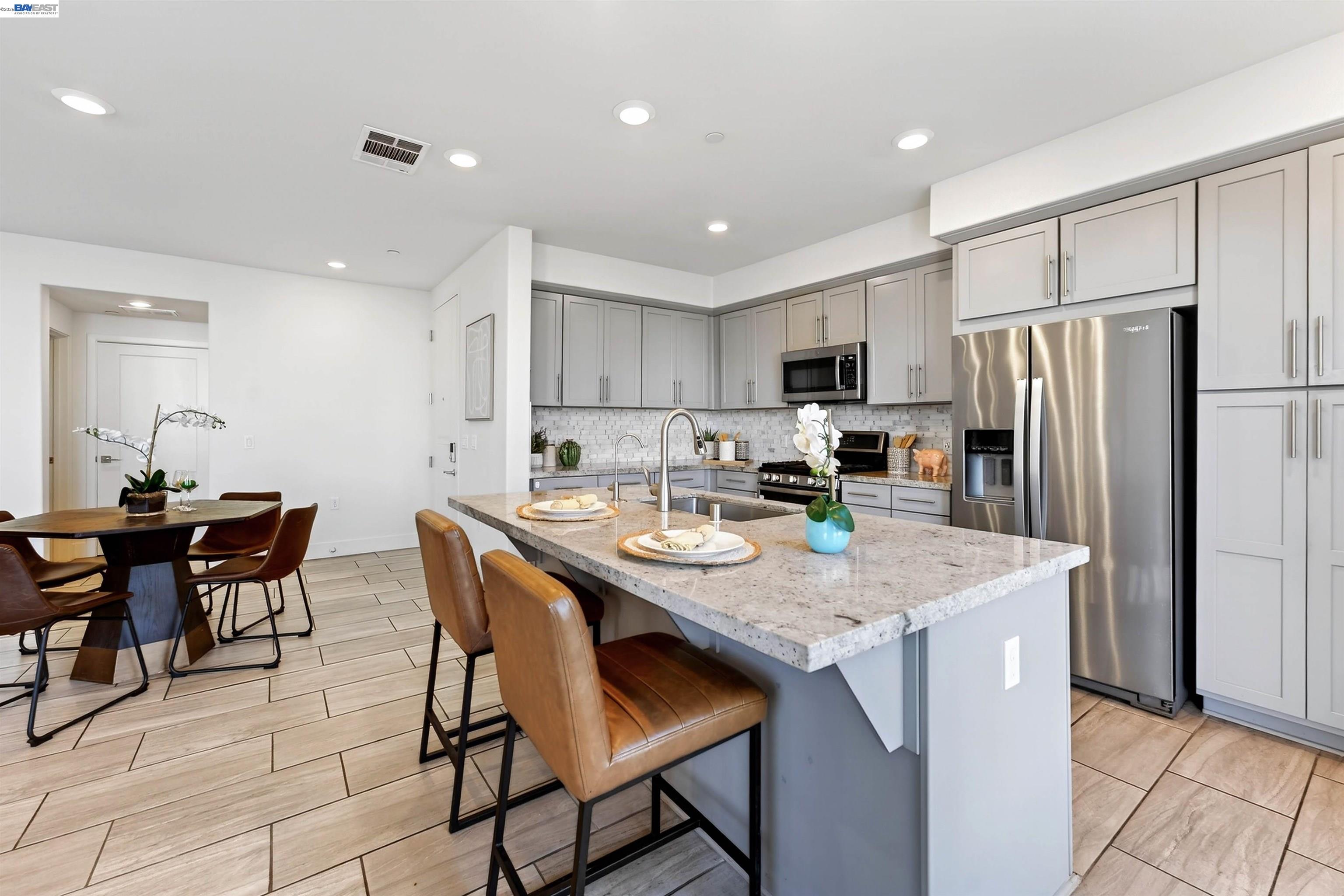 430 Montague Expressway, Unit 20 Milpitas, CA 95035 - Photo 8 of 50 a kitchen with stainless steel appliances granite countertop a table chairs sink refrigerator and microwave