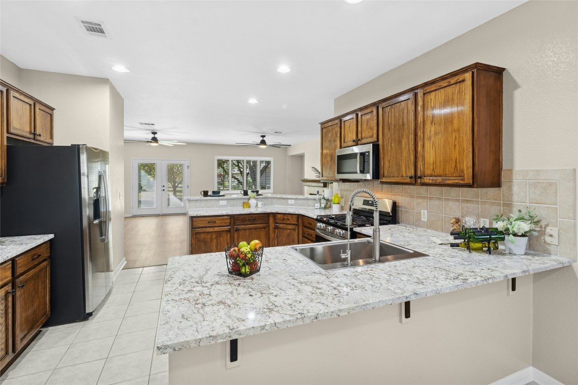 110 Crosby Street Georgetown, TX 78633 - Photo 11 of 40 a kitchen with stainless steel appliances granite countertop a sink refrigerator and microwave