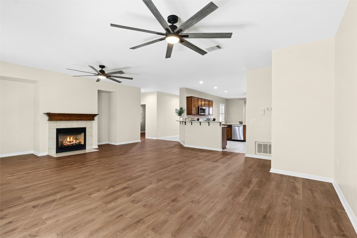 110 Crosby Street Georgetown, TX 78633 - Photo 5 of 40 a view of a livingroom with a fireplace a ceiling fan and a kitchen counter top space