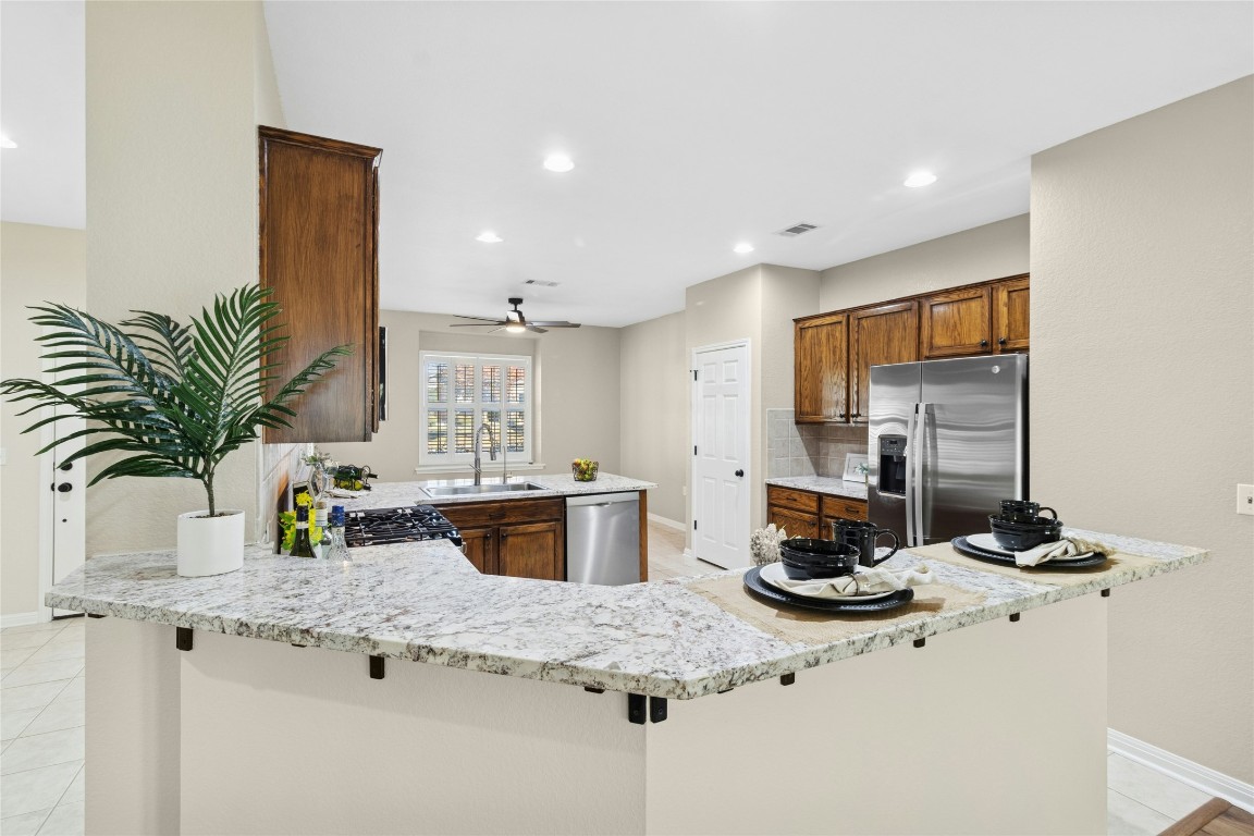110 Crosby Street Georgetown, TX 78633 - Photo 8 of 40 a kitchen with stainless steel appliances kitchen island granite countertop a sink stove and cabinets