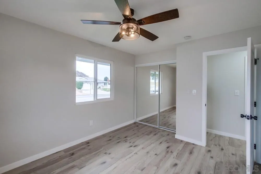 5886 Cowles Mountain Boulevard La Mesa, CA 91942 - Photo 24 of 39 an empty room with wooden floor fan and windows