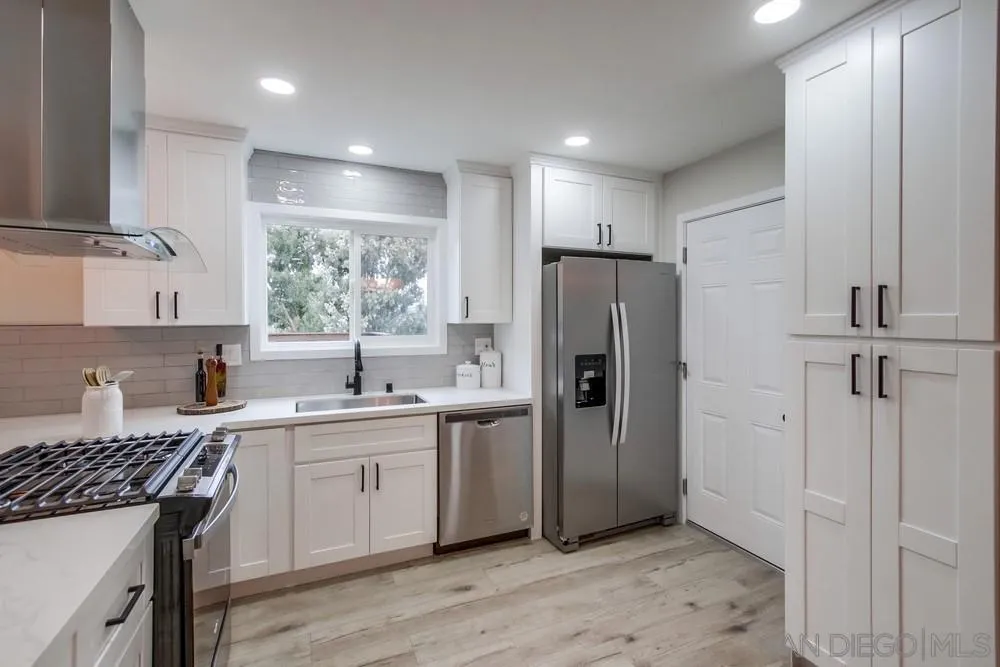 5886 Cowles Mountain Boulevard La Mesa, CA 91942 - Photo 10 of 39 a kitchen with stainless steel appliances a refrigerator a sink a stove a cabinets and wooden floor