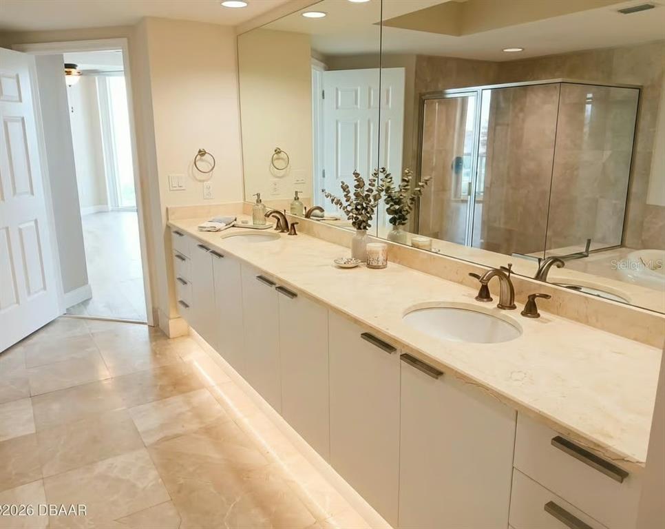 231 Riverside Drive, Unit 3081 Daytona Beach, FL 32117 - Photo 11 of 15 a bathroom with a double vanity sink mirror and double