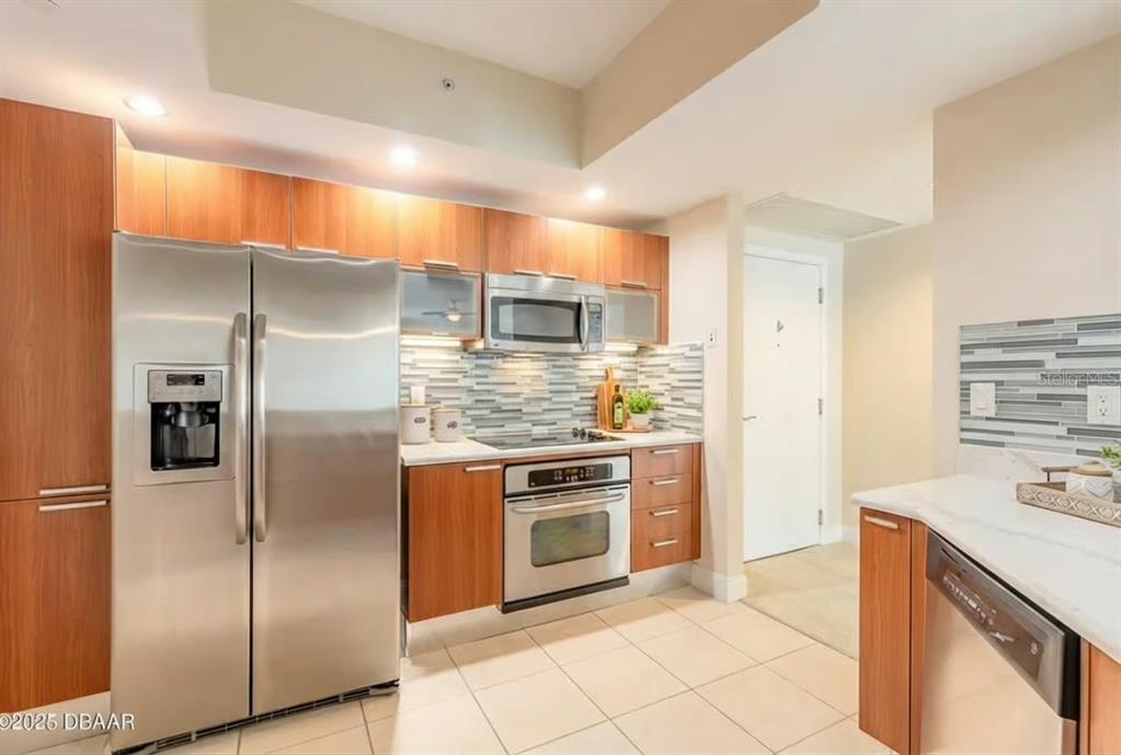 231 Riverside Drive, Unit 3081 Daytona Beach, FL 32117 - Photo 6 of 15 a kitchen with stainless steel appliances granite countertop a refrigerator and a stove