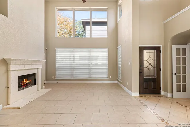 an empty room with windows and fireplace