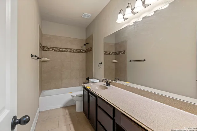 a bathroom with a double vanity sink a toilet and a bathtub