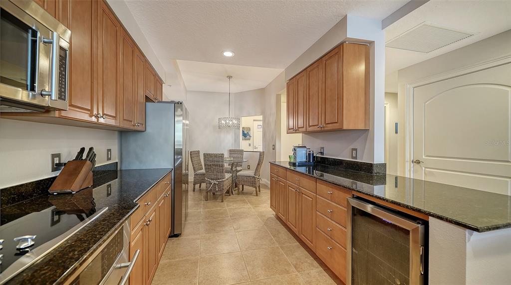 610 Riviera Dunes Way, Unit 306 Palmetto, FL 34221 - Photo 13 of 58 a kitchen with granite countertop a sink stove and cabinets