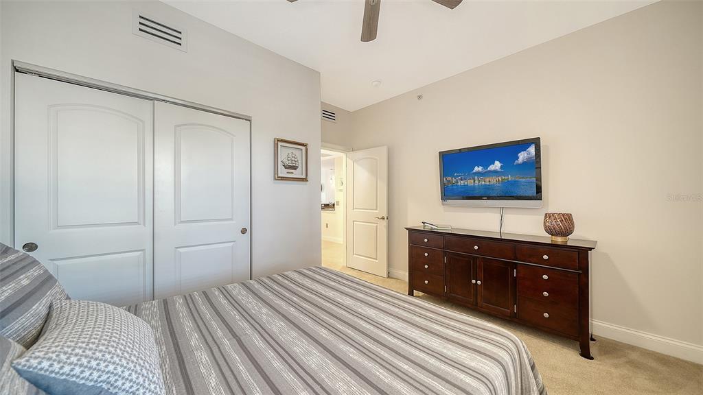 610 Riviera Dunes Way, Unit 306 Palmetto, FL 34221 - Photo 38 of 58 a bedroom with a bed and a dresser