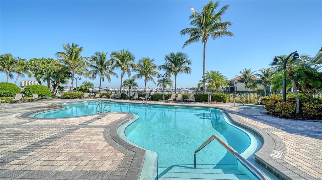 610 Riviera Dunes Way, Unit 306 Palmetto, FL 34221 - Photo 45 of 58 a view of a swimming pool with a table and chairs