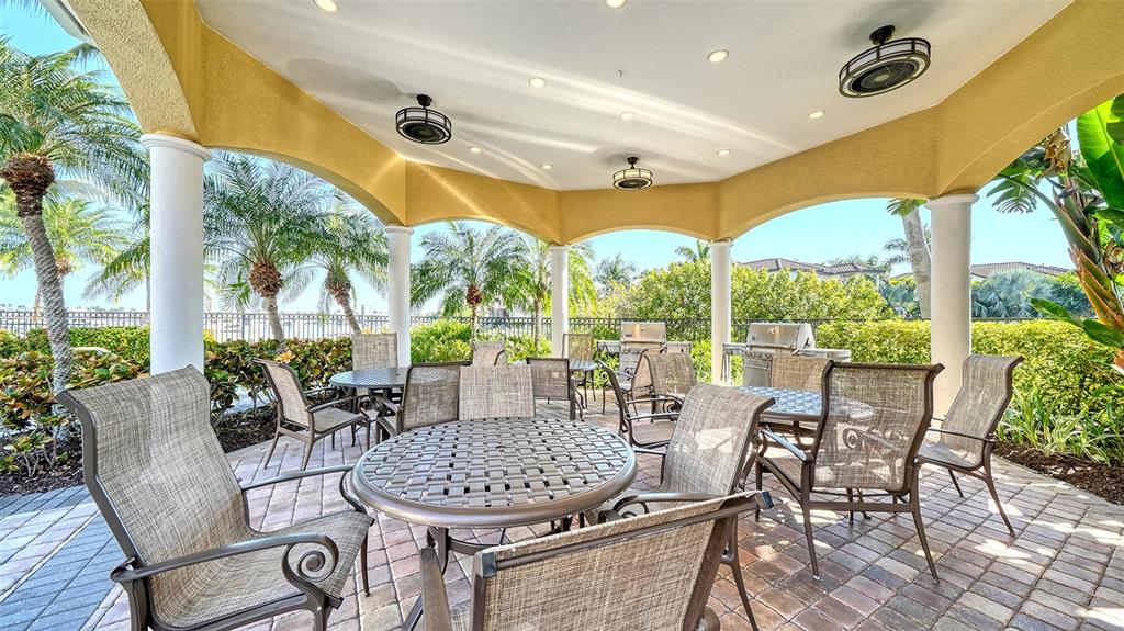 610 Riviera Dunes Way, Unit 306 Palmetto, FL 34221 - Photo 48 of 58 a view of a patio with a table and chairs