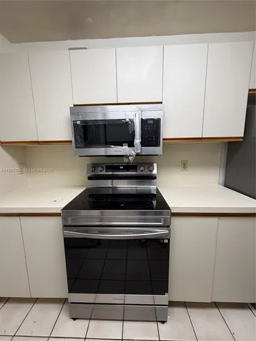 a kitchen with granite countertop a stove and a microwave