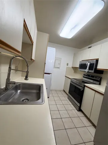 a kitchen with stainless steel appliances a refrigerator sink and stove