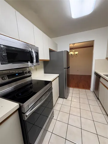 a kitchen with a refrigerator a stove and a sink