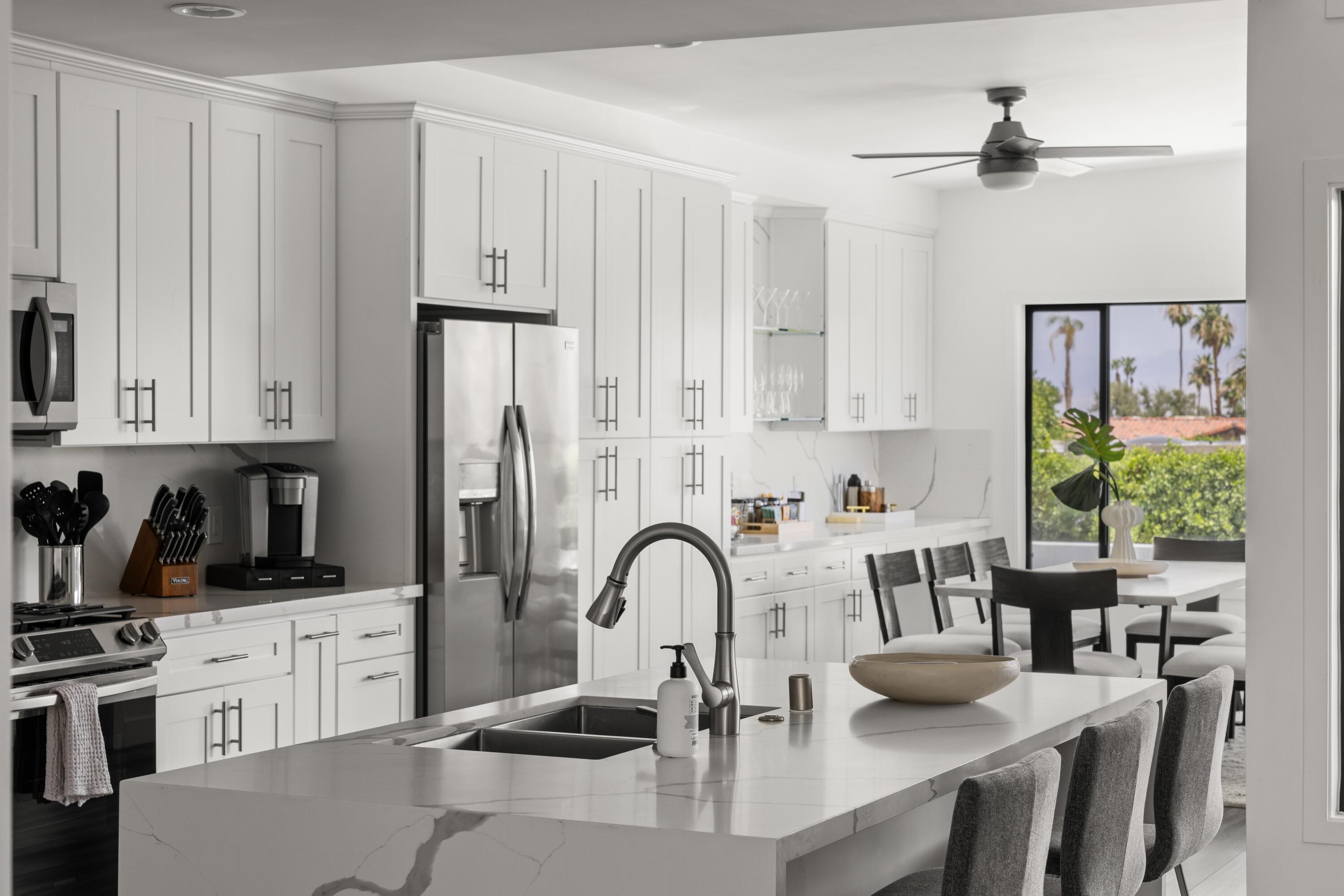 72870 Bel Air Road, Unit 4 Palm Desert, CA 92260 - Photo 6 of 36 a kitchen with stainless steel appliances granite countertop a stove a sink dishwasher and white cabinets with wooden floor