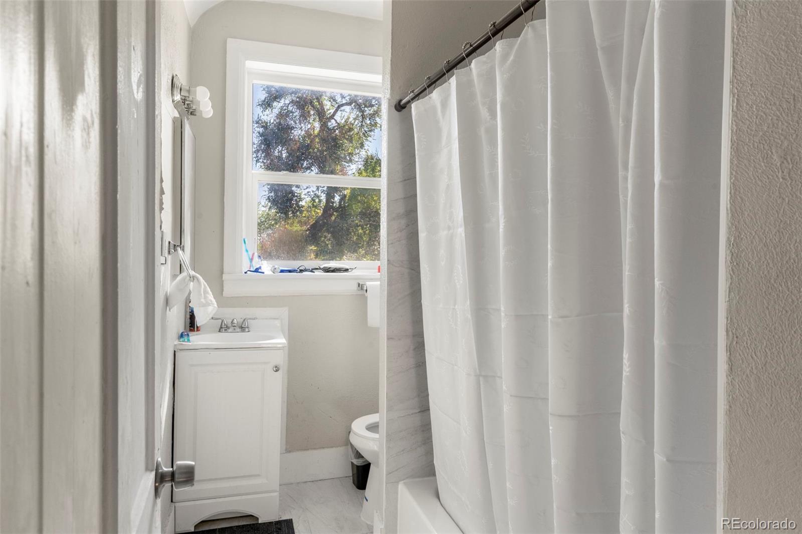1558 Dallas Street Aurora, CO 80010 - Photo 18 of 24 a bathroom with a sink a toilet and a mirror