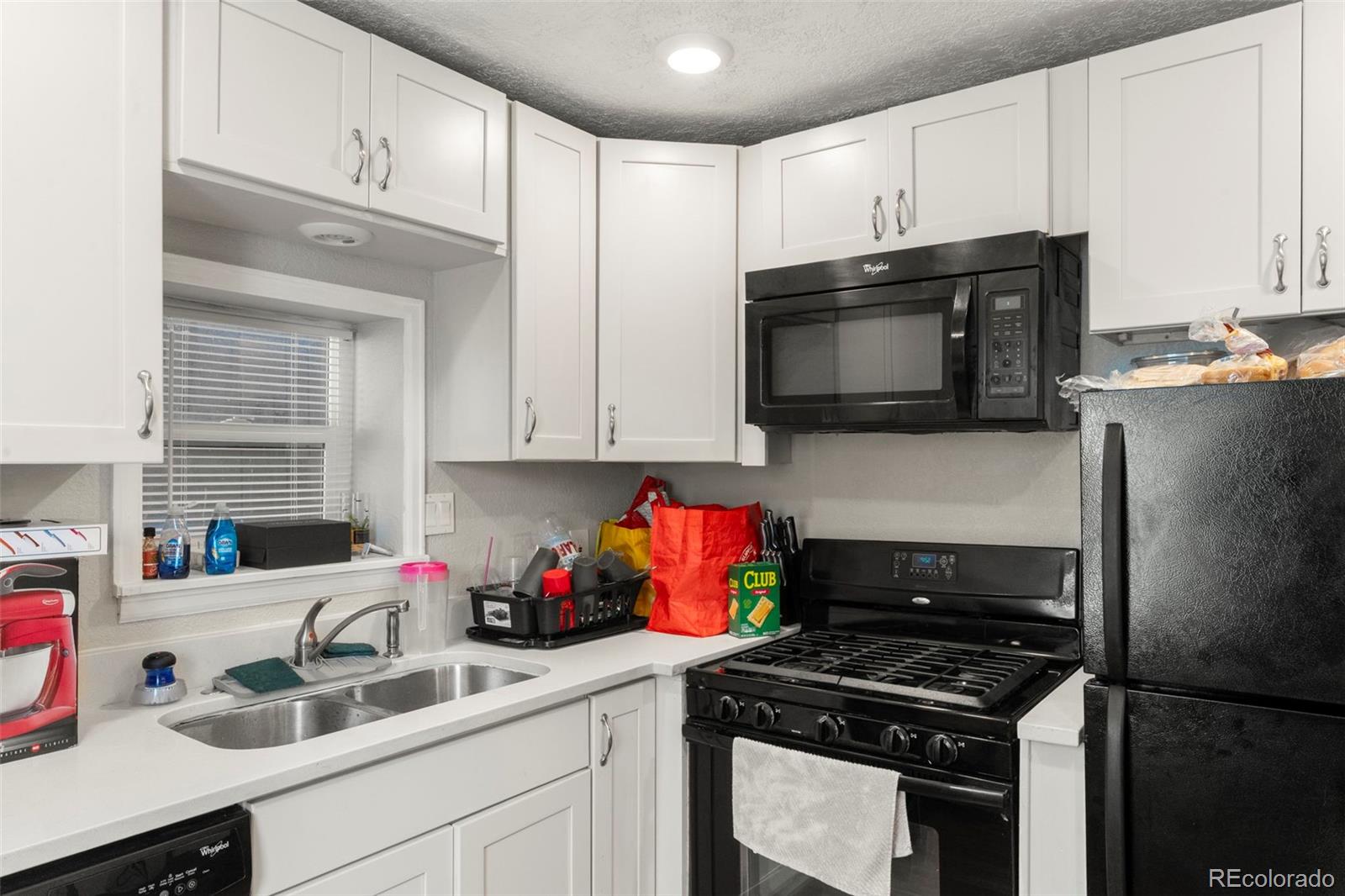 1558 Dallas Street Aurora, CO 80010 - Photo 8 of 24 a kitchen with stainless steel appliances a sink dishwasher stove microwave and refrigerator