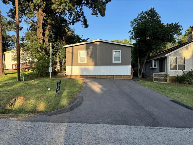 a view of a big house with a big yard and large trees