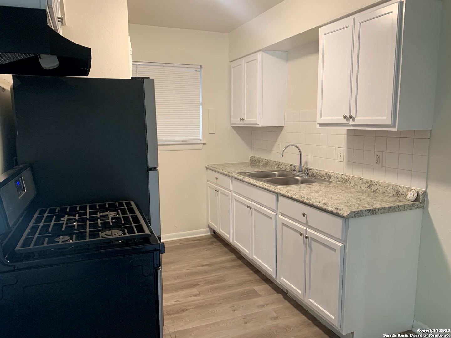 3915 Sherril Brook Road, Unit 4 San Antonio, TX 78228 - Photo 5 of 6 a kitchen with granite countertop a sink a stove and cabinets