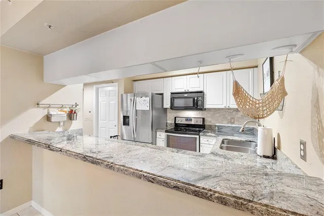 a open kitchen with stainless steel appliances granite countertop a sink stove and refrigerator