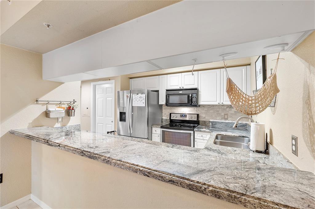 6926 West Sample Road, Unit 6926 Coral Springs, FL 33067 - Photo 11 of 41 a open kitchen with stainless steel appliances granite countertop a sink stove and refrigerator