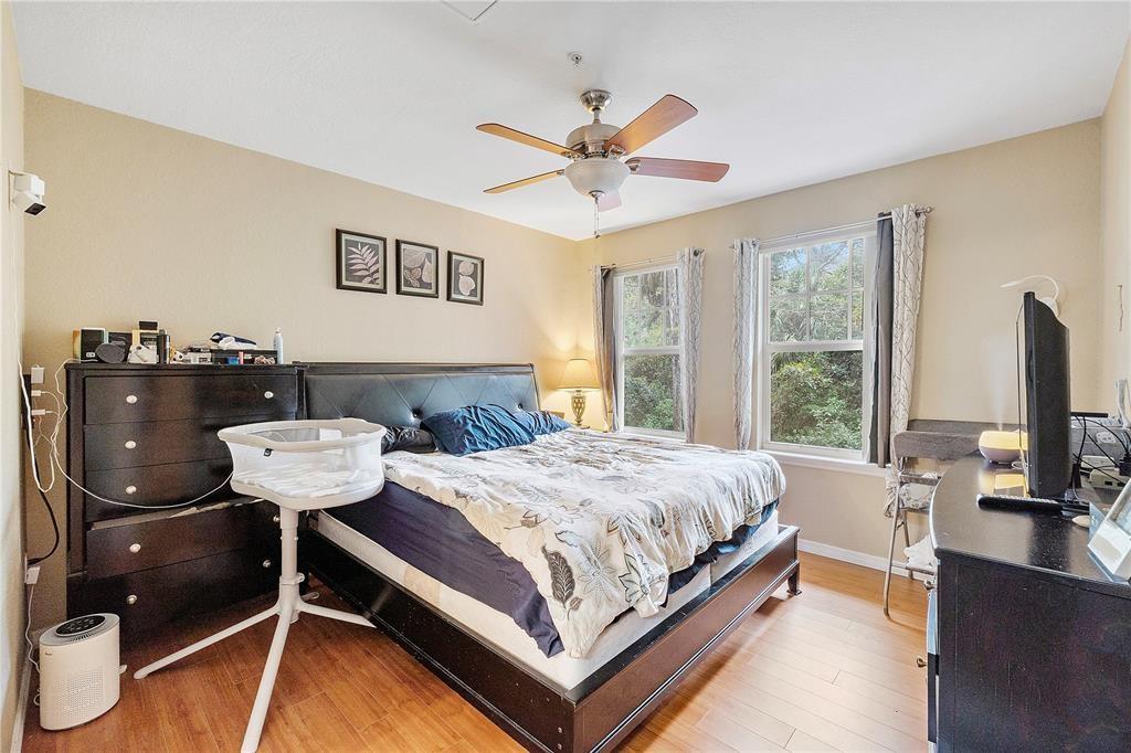 6926 West Sample Road, Unit 6926 Coral Springs, FL 33067 - Photo 20 of 41 a bedroom with a bed window and a chandelier